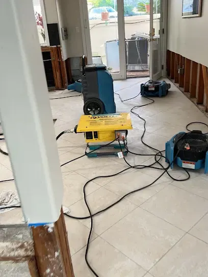Dehumidifier and air movers drying a tiled room with baseboards pulled in Palmdale