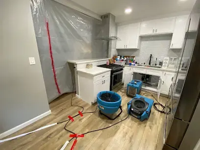 Plastic containment and air movers set up in a Palmdale kitchen during a dry-out