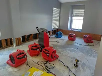 Red air movers and an extractor drying a subfloor after flooring removal in Palmdale