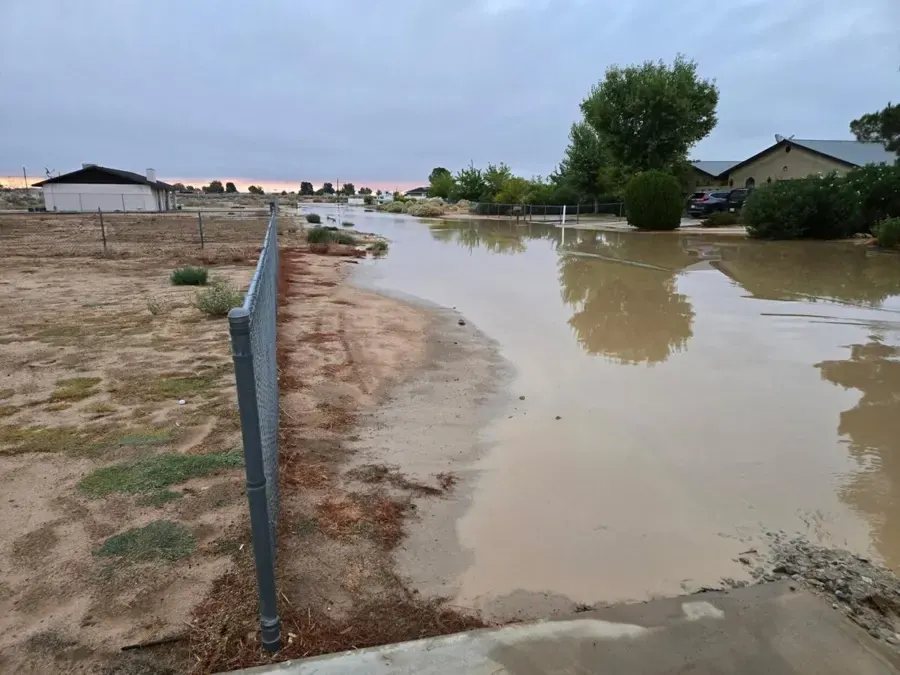 Storm runoff pooled across a desert lot beside homes in the Antelope Valley near Palmdale